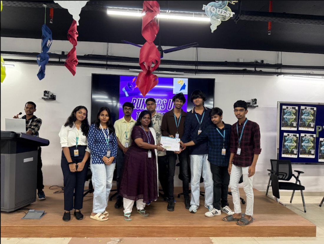 PyQuest 2025 winners on stage with a faculty member